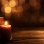 A candle with warm light in the background